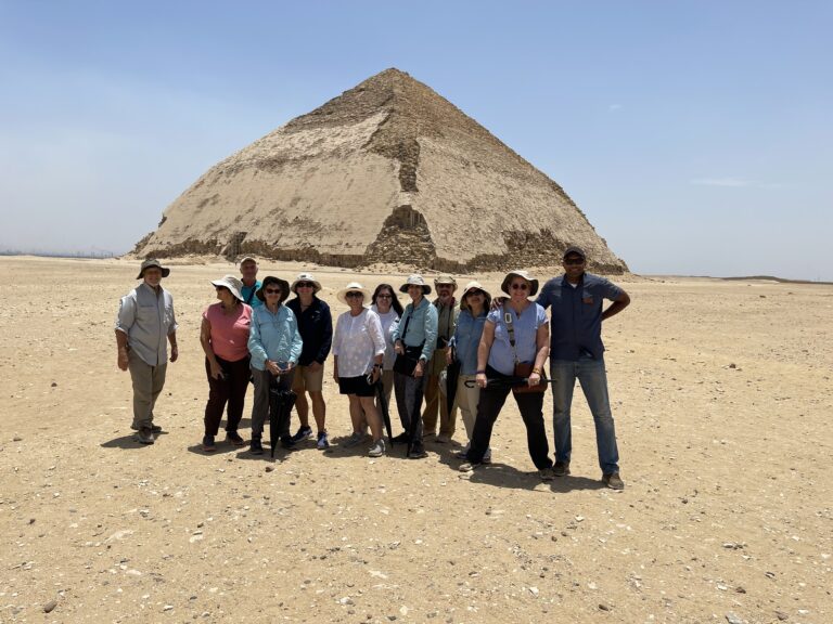 a photo showing a group of people taking a photo in front of Saqqara pyramid in Egypt
