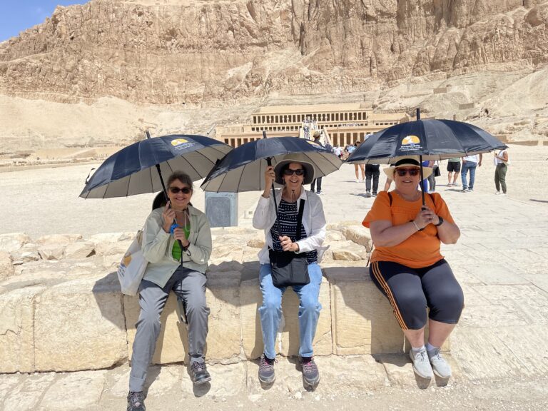 Tourists with umbrellas enjoying their time in Hatshepsut temple in Luxor