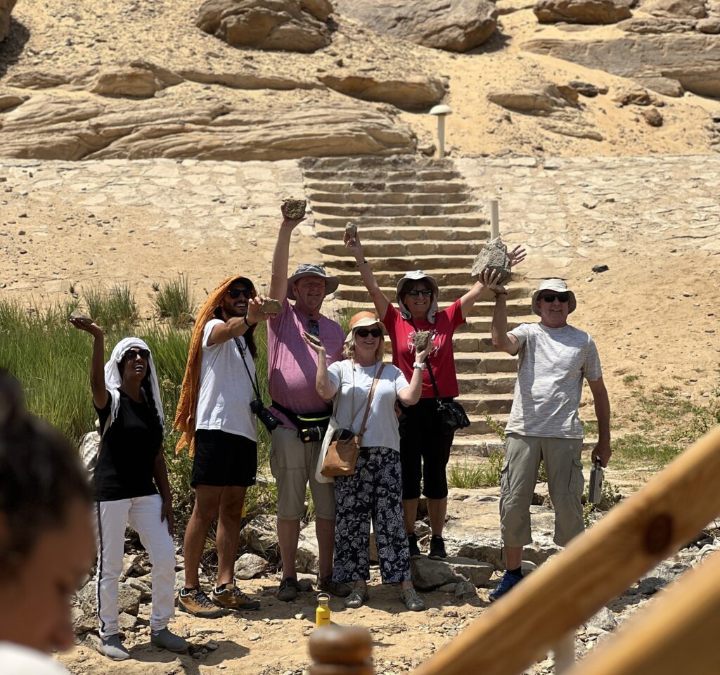 a photo of a group of tourists with their guide enjoying the weird shaped rocks in Gebel Silsila Stone Quarry