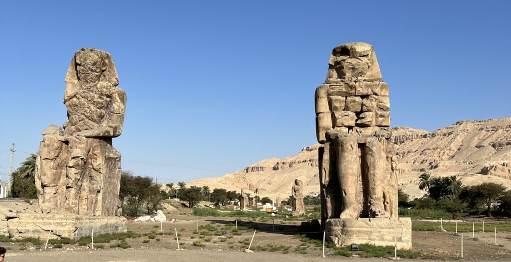 a photo showing The Colossus of Memnon in Luxor, Egypt
