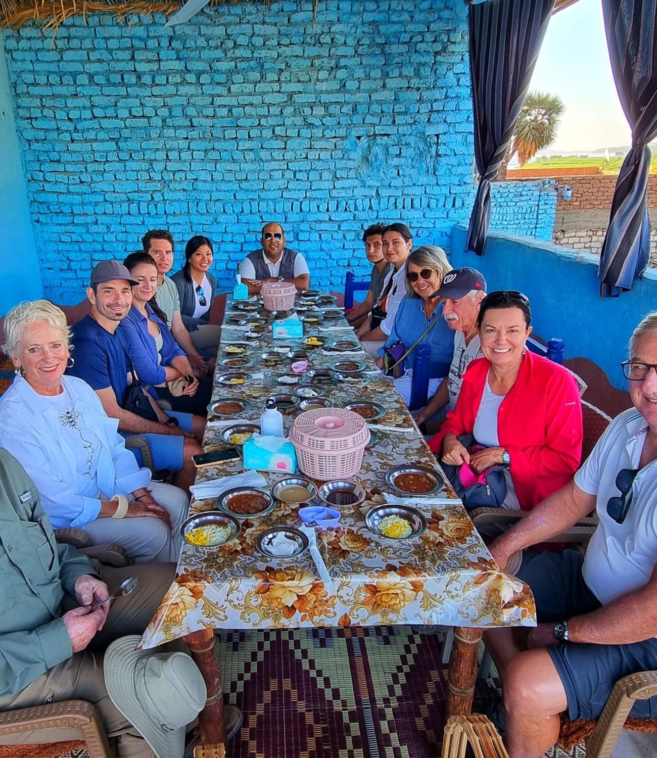 a photo showing a group of tourists having breakfast in a Bisaw's local house